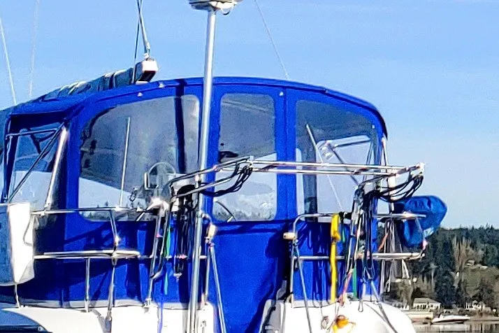 Slide: The Image of Catalina 380 sailboat, 2000 model, featuring a blue canopy and rigging, docked in a marina. - 26