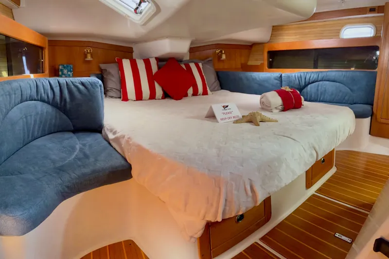 Slide: The Image of Cozy cabin interior of 2000 Catalina 380 sailboat with plush bedding and wooden accents. - 9
