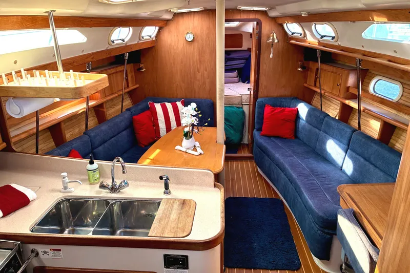 Slide: The Image of Interior of a 2000 Catalina 380 sailboat with cozy seating and wooden finishes. - 3
