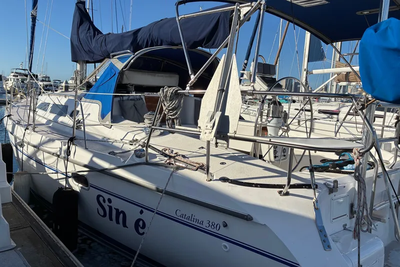 Slide: The Image of Sailboat Catalina 380, 2000 model, docked at marina with blue canopy and rigging. - 23