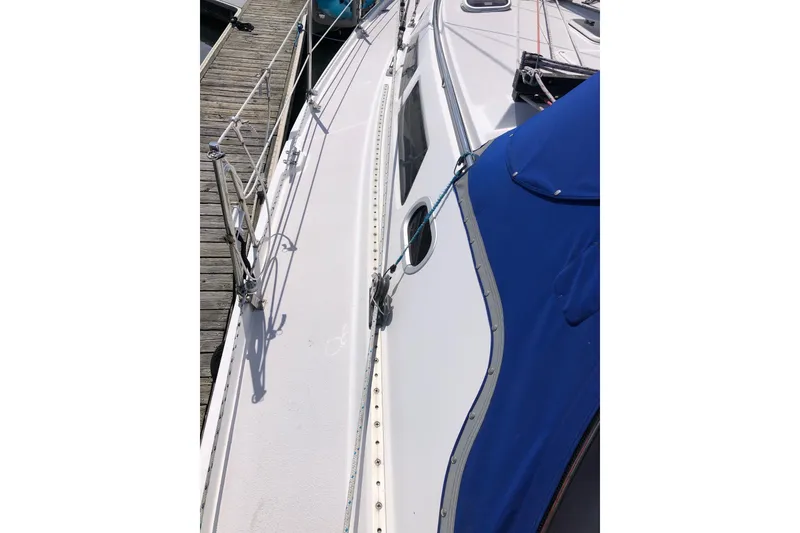 Slide: The Image of Catalina 380 sailboat deck, 2000 model, docked with blue cover and railing. - 18
