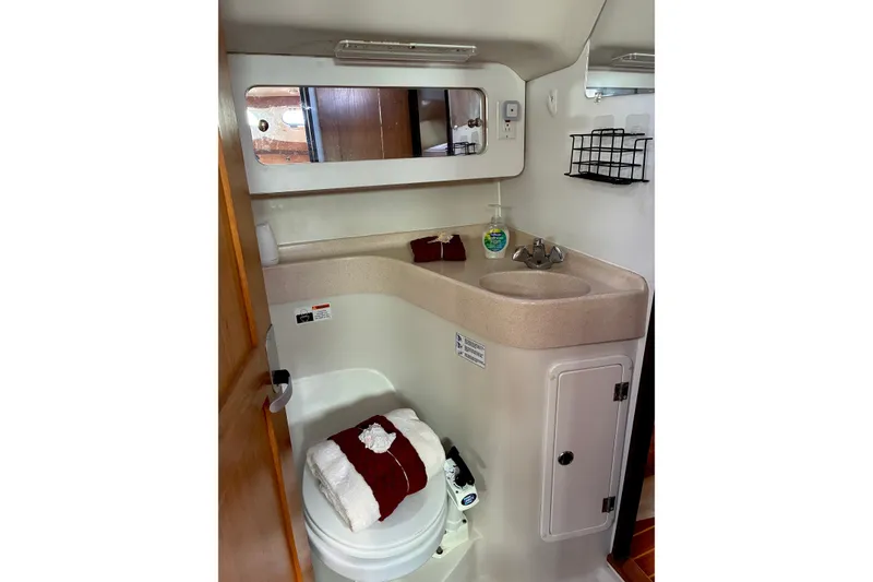 Slide: The Image of Bathroom interior of a 2000 Catalina 380 yacht, featuring a sink, mirror, and toilet. - 10