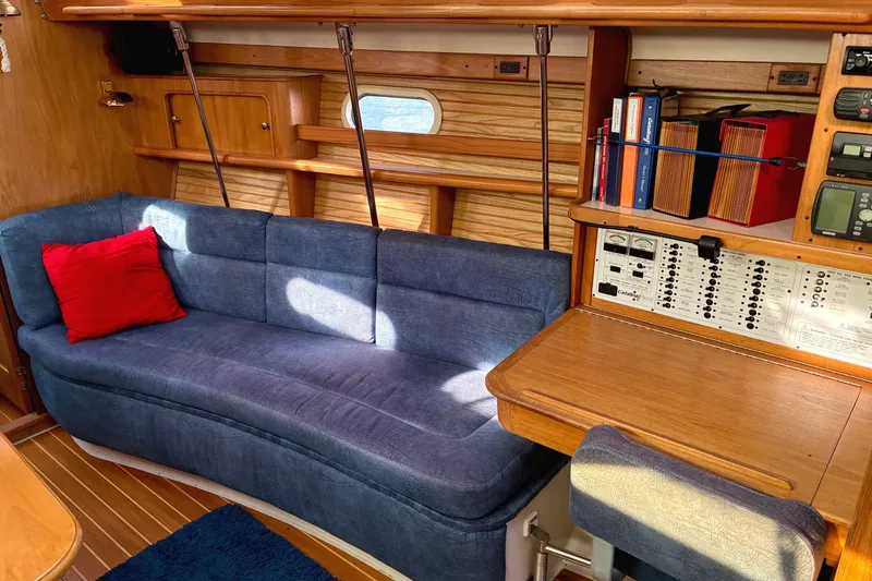 Slide: The Image of Interior of a 2000 Catalina 380 sailboat with blue sofa and navigation station. - 5