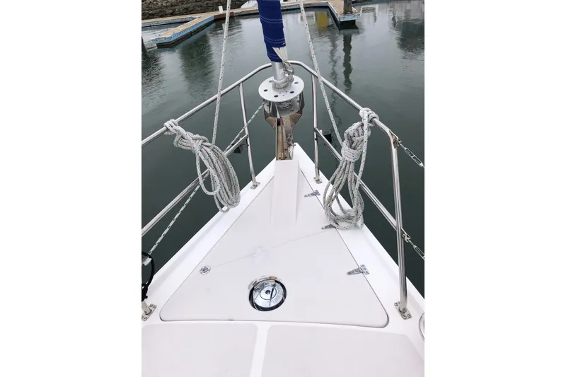 Slide: The Image of Bow of a 2000 Catalina 380 sailboat with ropes and anchor, docked in calm waters. - 15