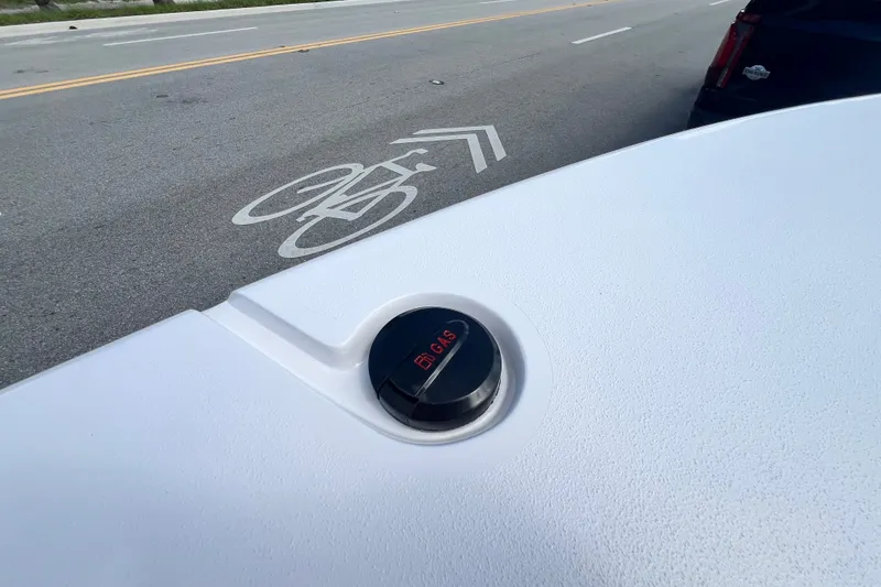 Slide: The Image of Gas cap on a 2025 Vtech 18 vehicle, near a bike lane marking. - 66