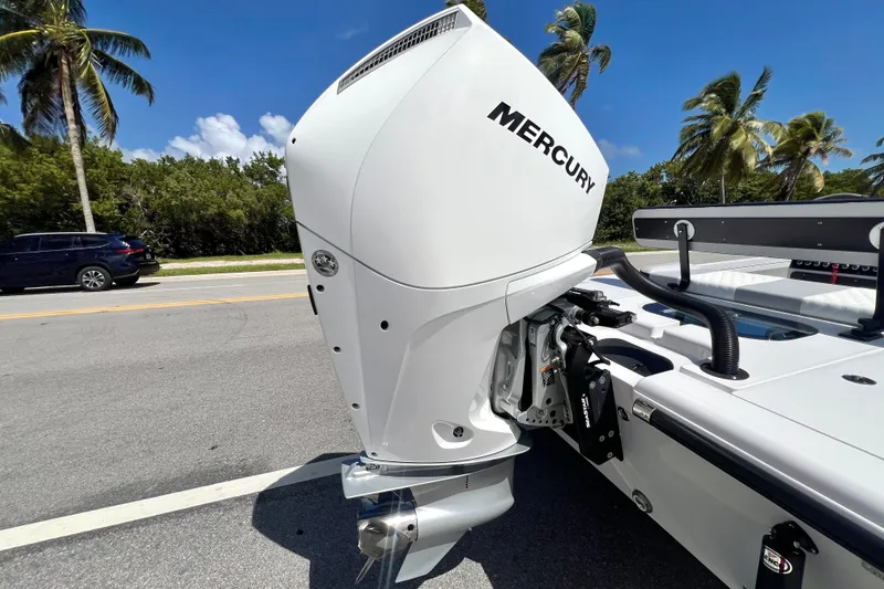 Slide: The Image of Custom Vtech 18 Flats 2025 boat with Mercury outboard motor, parked roadside under palm trees. - 3
