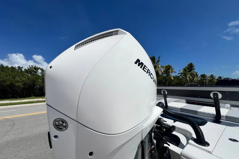 Slide: The Image of Outboard motor on a Custom Vtech 18 Flats boat, 2025 model, under clear blue sky. - 5