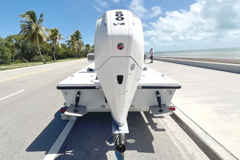 Slide: The Image of The image shows a boat with a large outboard motor on a trailer by a coastal road. - 8