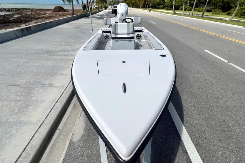 Slide: The Image of Custom Vtech 18 Flats boat on road, 2025 model, near beachside. - 21