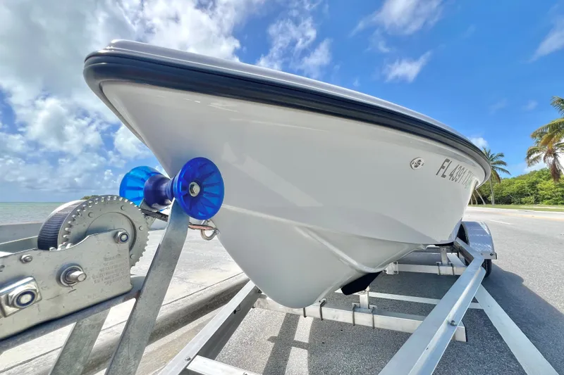 Slide: The Image of Custom Vtech 18 Flats boat on trailer under blue sky, 2025 model. - 17