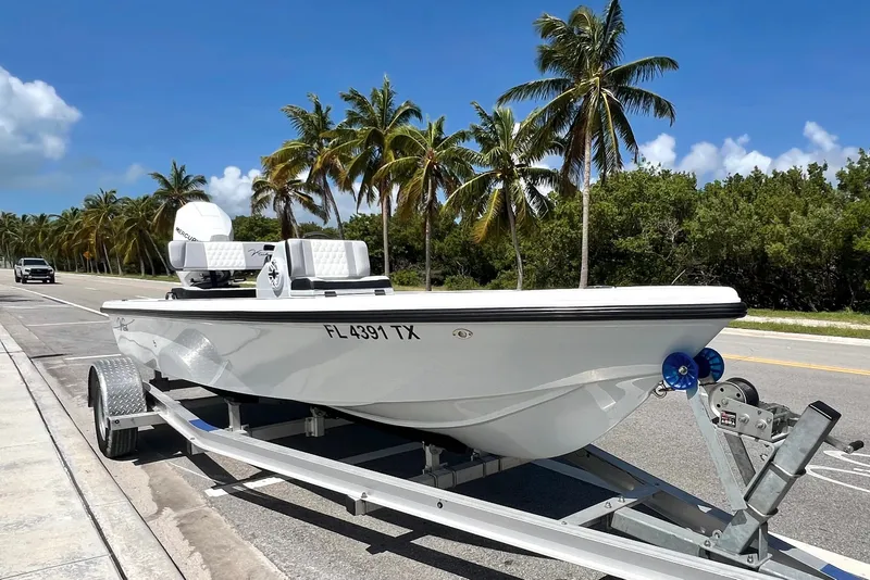 The Image of Custom Vtech 18 Flats boat on trailer, palm trees in background, sunny day. - 0