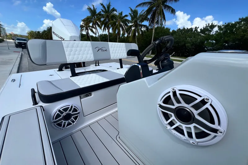 Slide: The Image of 2025 Vtech 18 boat interior with speakers, sleek seating, and palm trees in the background. - 39