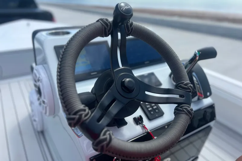 Slide: The Image of Steering wheel of a 2025 Vtech 18 boat with modern controls and display. - 53