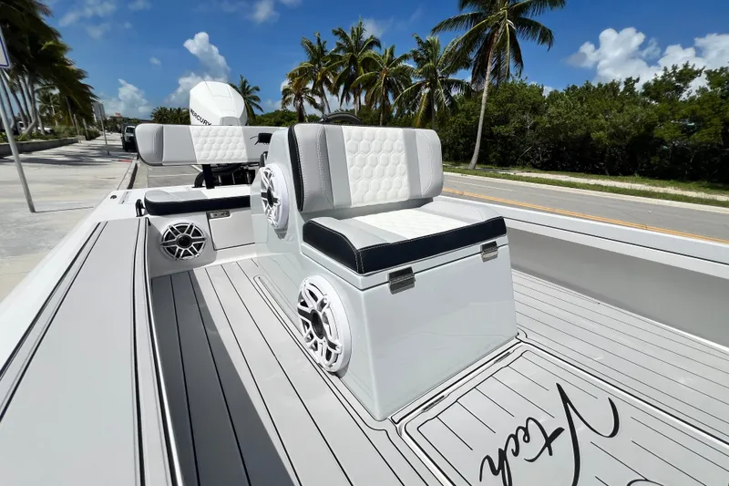 Slide: The Image of 2025 Vtech 18 boat interior with stylish seating, speakers, and palm trees in the background. - 33