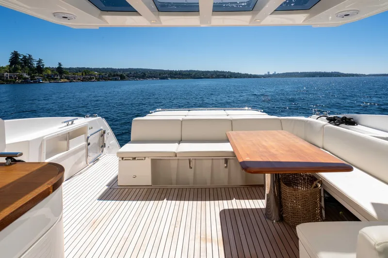 Slide: The Image of Luxurious 2015 Absolute 56 STC yacht deck with seating and table, overlooking serene waters. - 54