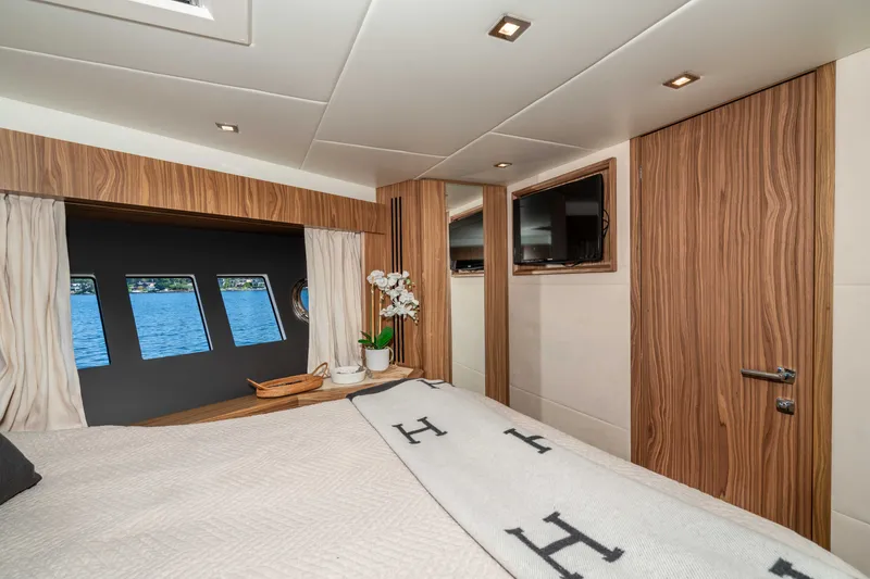 Slide: The Image of Luxurious 2015 Absolute 56 STC yacht bedroom with elegant wood finishes and scenic window views. - 48