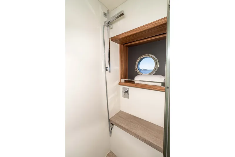 Slide: The Image of Shower area in 2015 Absolute 56 STC yacht with porthole and wooden shelving. - 51