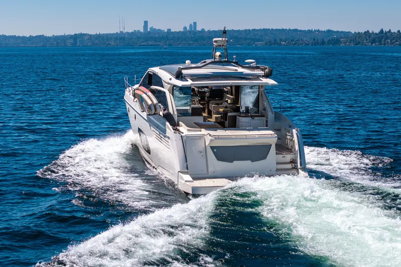Slide: The Image of Luxury yacht Absolute 56 STC cruising on blue waters, city skyline in background. - 14