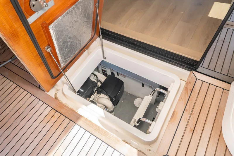 Slide: The Image of Engine compartment of a 2015 Absolute 56 STC yacht, featuring wooden deck panels. - 67