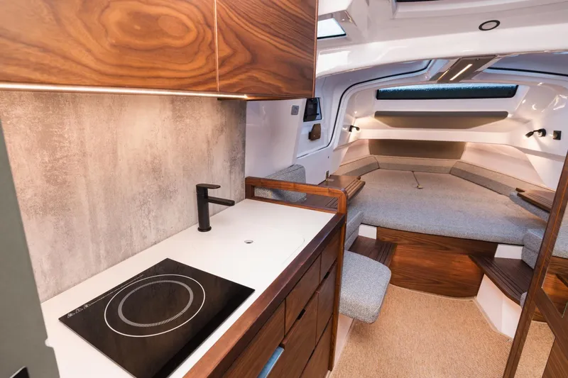 Slide: The Image of Luxurious interior of 2027 Axopar 38 XC Cross Cabin with modern kitchenette and cozy seating area. - 23