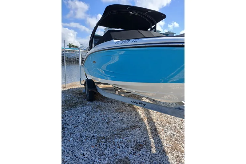 The Image of 2022 Sea Ray SPX 190 Outboard boat on trailer, blue hull, sunny day. - 0