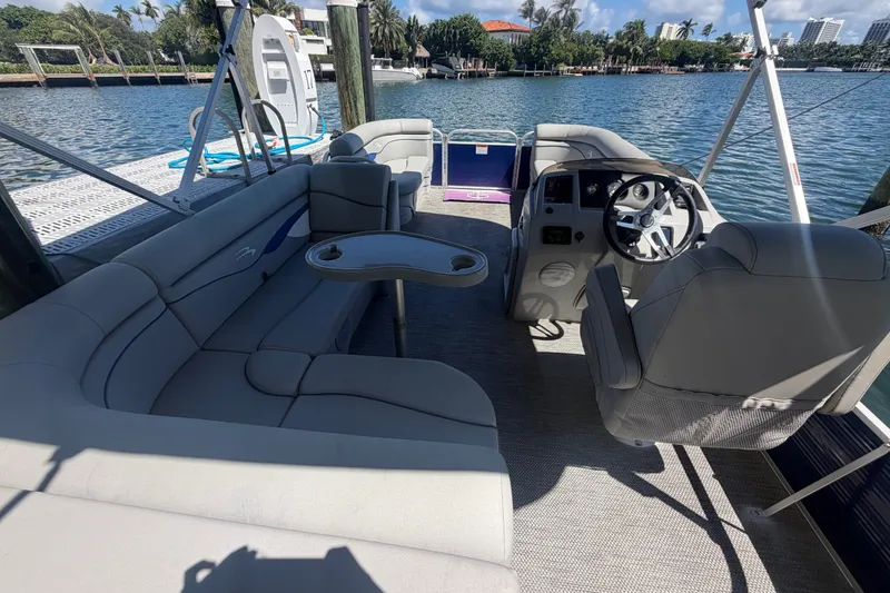 Slide: The Image of 2023 Bennington 20 SVL pontoon boat interior with plush seating and steering console. - 5