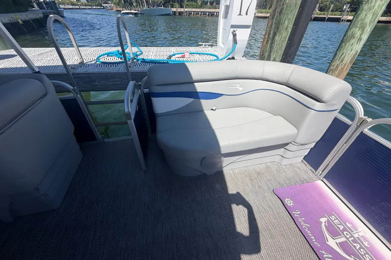 Slide: The Image of 2023 Bennington 20 SVL pontoon boat interior with gray seating and dock view. - 16