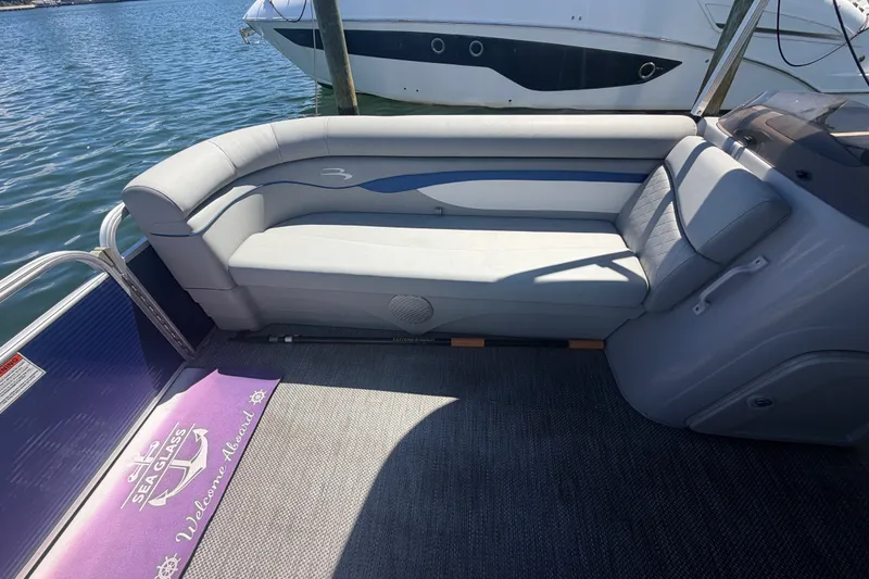 Slide: The Image of 2023 Bennington 20 SVL pontoon boat interior with comfortable seating and welcome mat. - 17