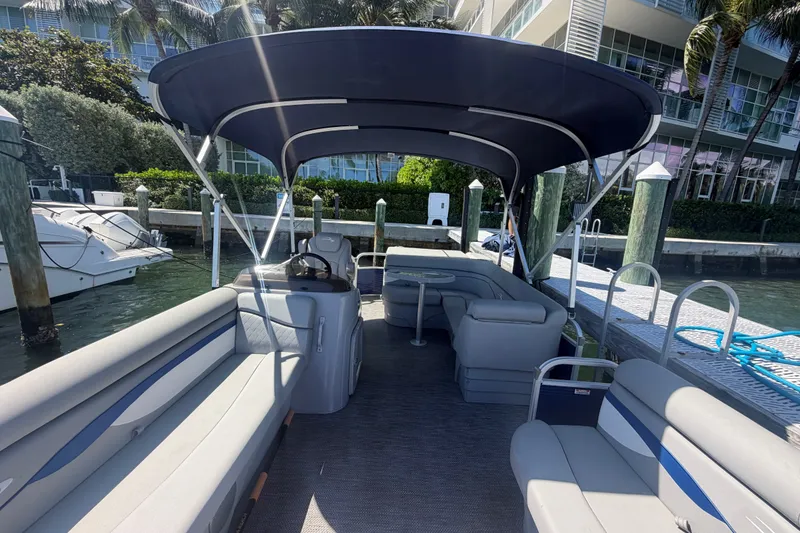 Slide: The Image of 2023 Bennington 20 SVL pontoon boat docked, featuring spacious seating and canopy. - 18
