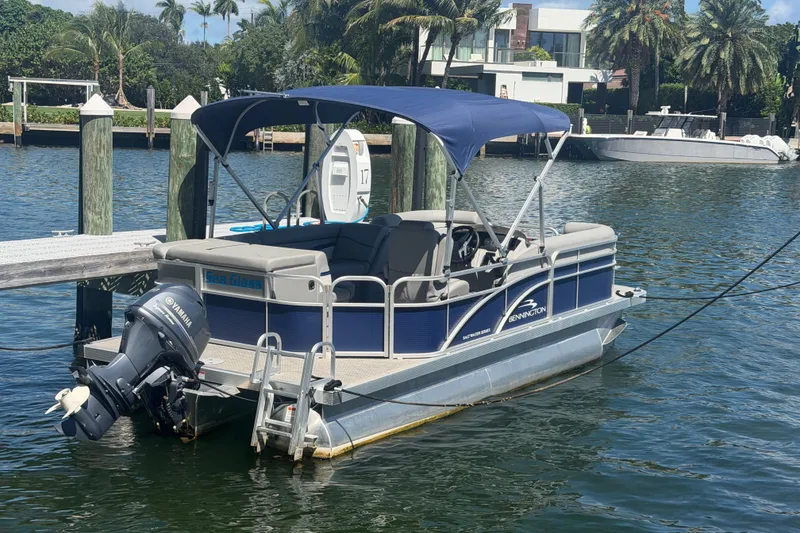 Slide: The Image of 2023 Bennington 20 SVL pontoon boat docked with Yamaha outboard motor. - 2