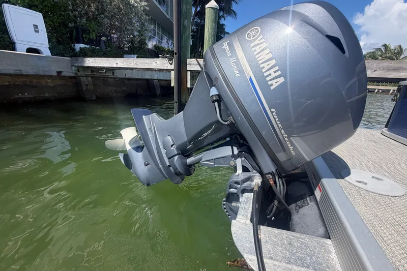 Slide: The Image of 2023 Bennington 20 SVL with Yamaha outboard motor docked by the water. - 19