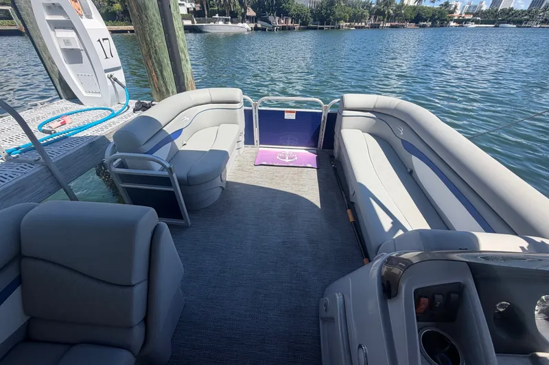 Slide: The Image of 2023 Bennington 20 SVL pontoon boat interior with plush seating and waterfront view. - 15