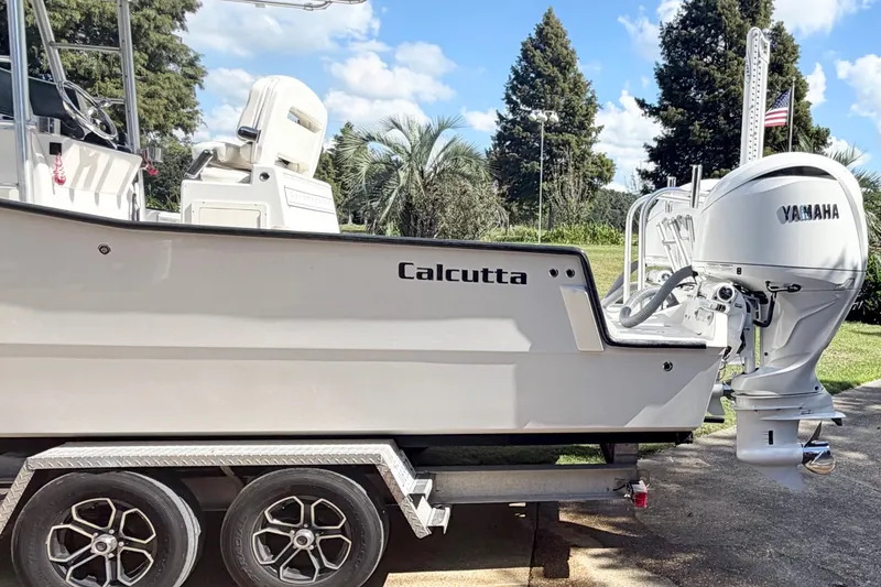 Slide: The Image of Calcutta 263 boat on trailer with Yamaha engine, 2015 model, outdoors under blue sky. - 12