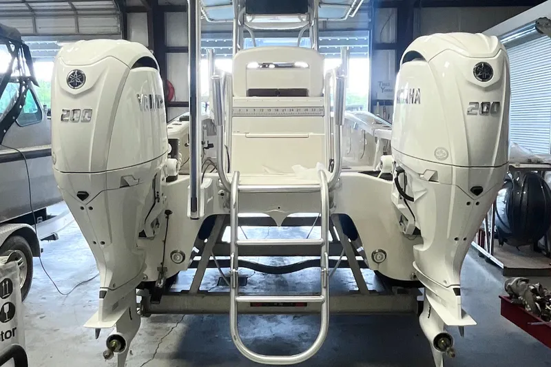 Slide: The Image of Twin Yamaha 200 outboard engines on a 2015 Calcutta 263 boat in a garage. - 2