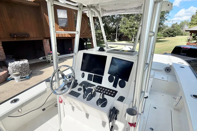 Slide: The Image of Center console of a 2015 Calcutta 263 boat with dual screens and steering wheel. - 15