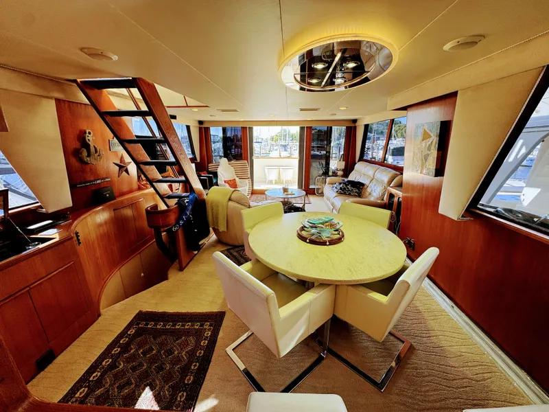 Slide: The Image of Interior of a luxury yacht with round table, white chairs, and large windows. - 31