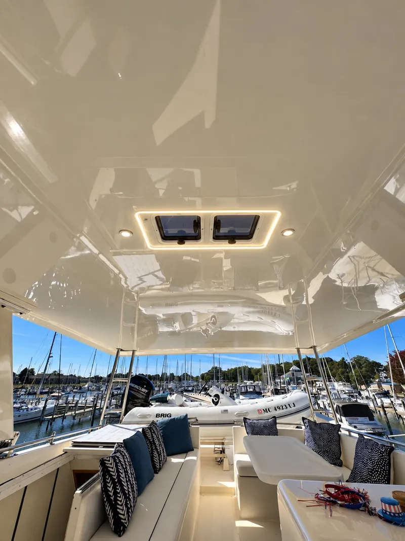Slide: The Image of The image shows a spacious yacht deck with comfortable seating and a view of a marina. - 20
