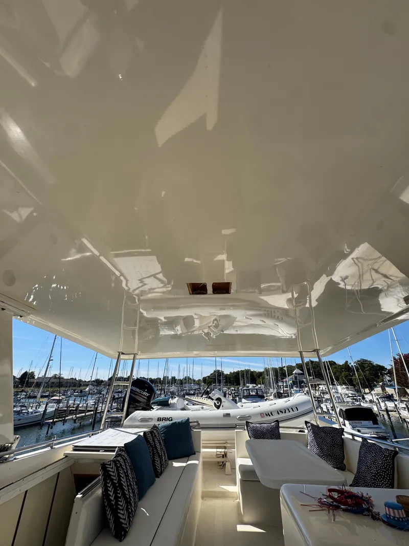 Slide: The Image of The image shows the spacious deck of a 1990 Viking 55 Motor Yacht Wide Body with elegant seating. - 21