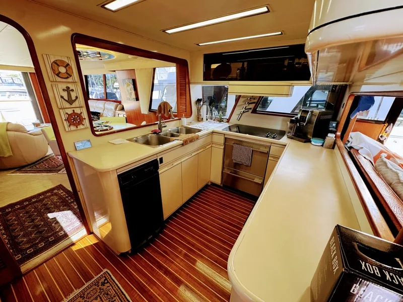 Slide: The Image of The galley of a 1990 Viking 55 Motor Yacht Wide Body with modern appliances and wood paneling. - 36