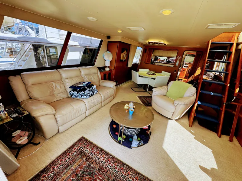 Slide: The Image of Interior of a 1990 Viking 55 Motor Yacht with beige sofa, carpet, and dining table. - 29