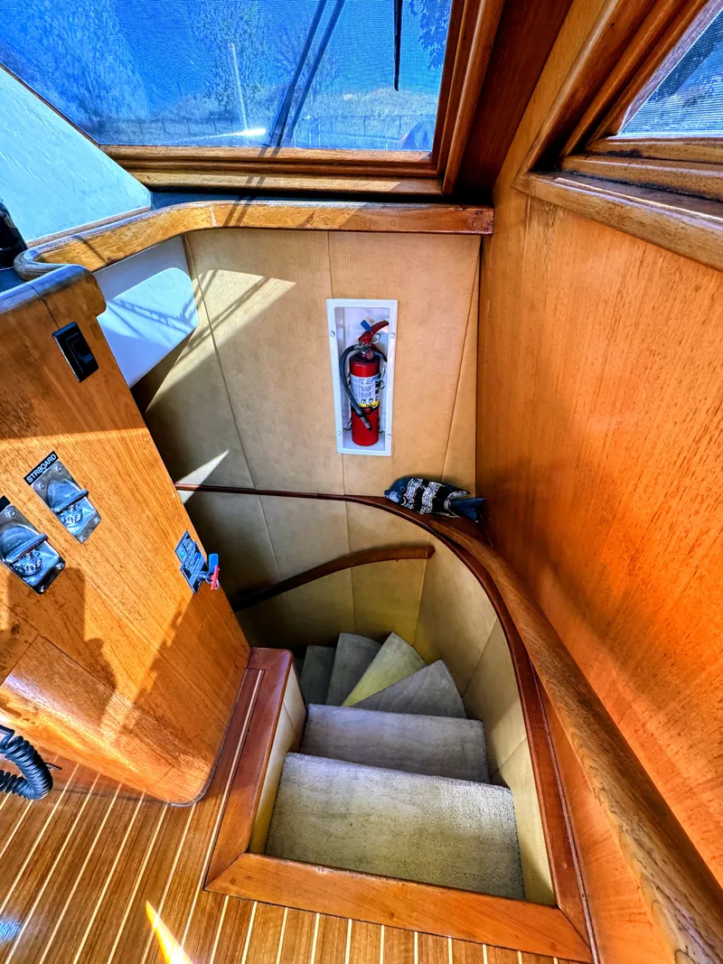 Slide: The Image of Staircase in a yacht with wooden walls and carpet, fire extinguisher on the wall. - 47