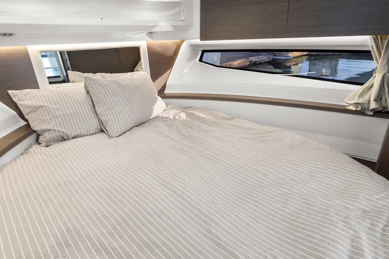 Slide: The Image of Cozy bedroom interior of 2025 Jeanneau NC 895 Series 2 yacht with striped bedding. - 15