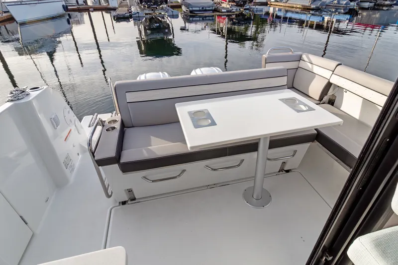Slide: The Image of 2025 Jeanneau NC 895 Series 2 boat interior with seating and table at marina. - 24