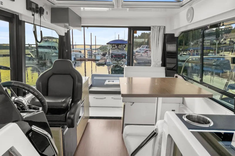 Slide: The Image of Interior of 2025 Jeanneau NC 895 Series 2 boat, featuring helm and dining area. - 4