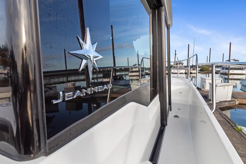 Slide: The Image of 2025 Jeanneau NC 895 Series 2 boat docked at marina, showcasing sleek design and branding. - 28