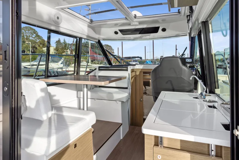 Slide: The Image of Interior of 2025 Jeanneau NC 895 Series 2 boat, featuring seating, table, and kitchenette. - 5