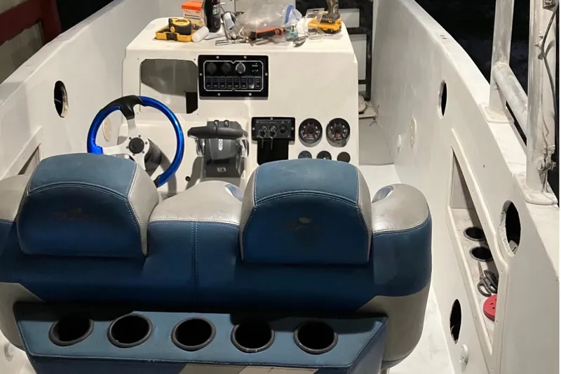 Slide: The Image of Interior of a 1990 Custom Center Console Signature boat with blue steering wheel and gauges. - 4