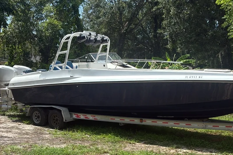 Slide: The Image of 1990 Custom Center Console Signature boat on trailer, surrounded by lush greenery. - 1
