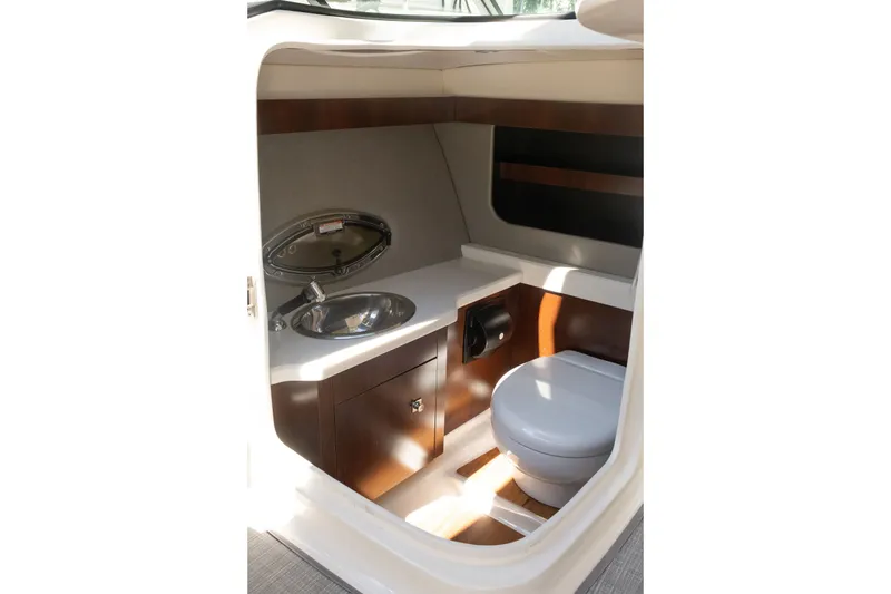 Slide: The Image of 2021 Chaparral 307 SSX boat interior with sink and toilet in compact bathroom. - 27