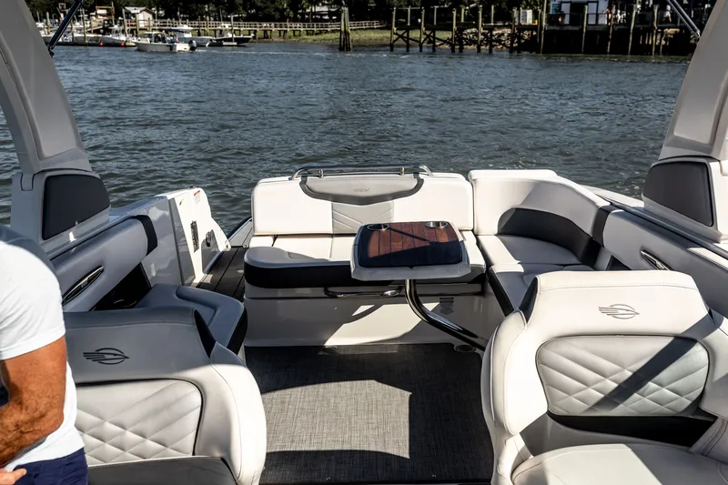 Slide: The Image of 2021 Chaparral 307 SSX boat interior with luxurious seating and table on the water. - 15